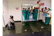 O româncă îngenuncheată în fața medicilor care i-au salvat băiatul de COVID este fotografia anului în Spania