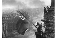 Imaginea emblematică a căderii Berlinului: un rus, cu două ceasuri la mână, ridică steagul Armatei Roșii deasupra Reichstag-ului